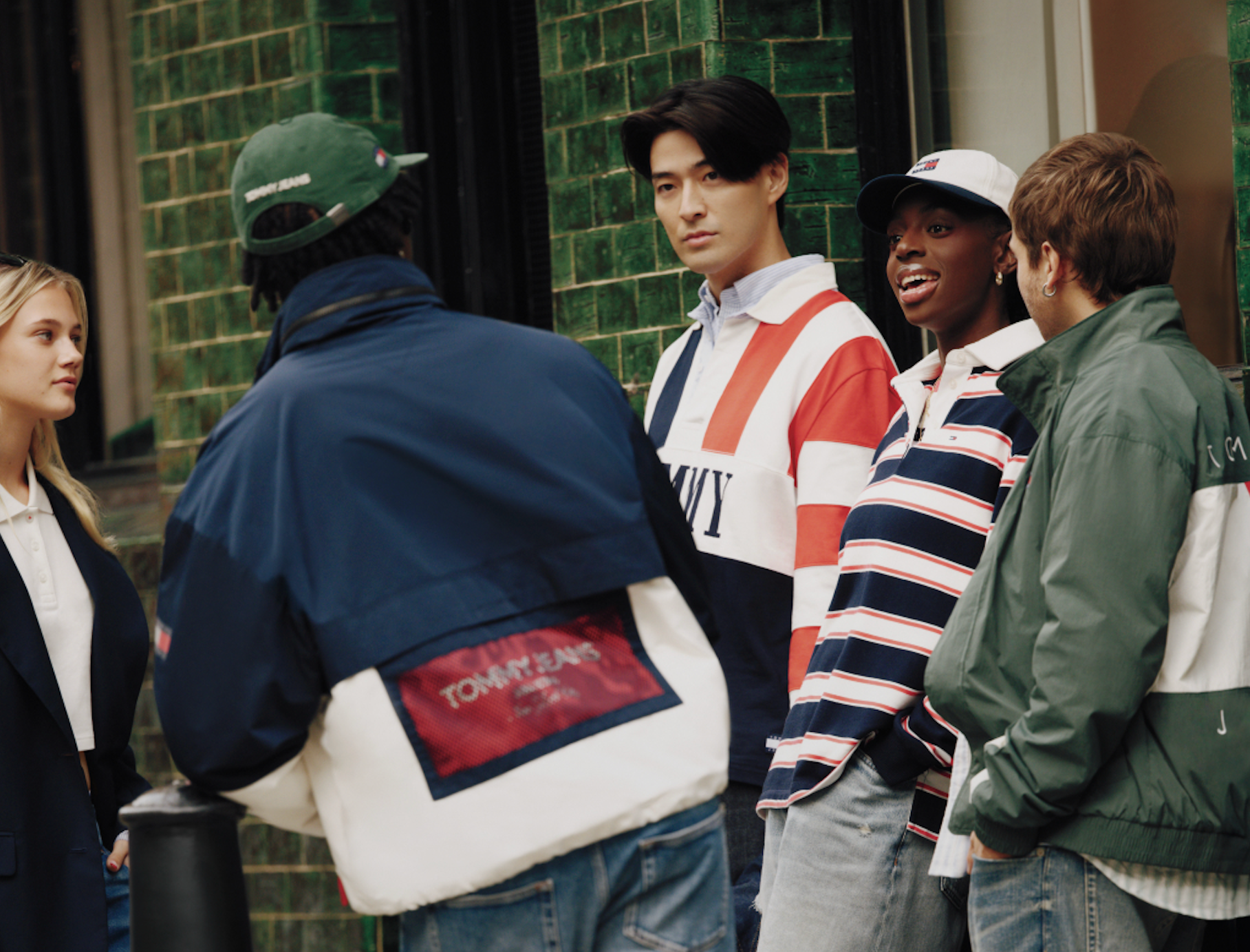 Tommy Jeans menswear styled on a group of models wearing casual streetwear in an urban setting